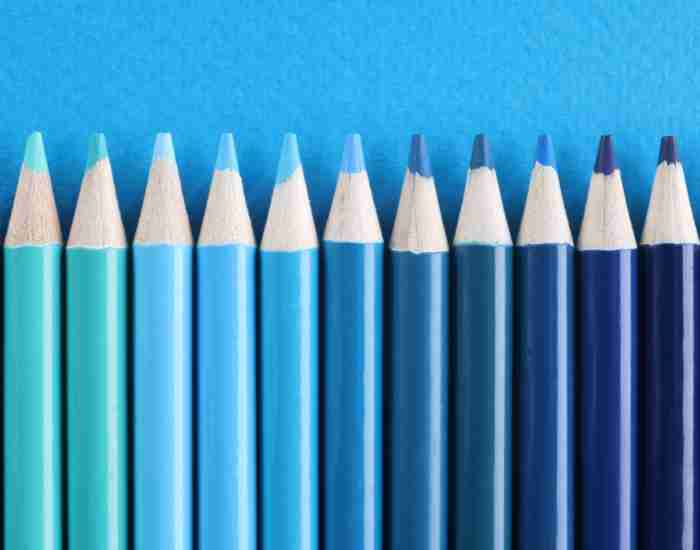 Wooden Pencils of Different Blue Shades on Light Blue Background